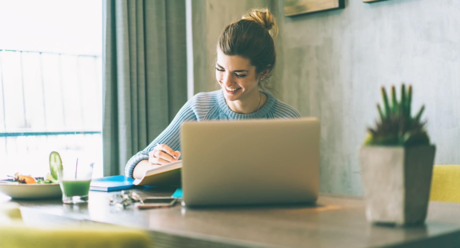 Person reviewing financial documents with calculator and laptop